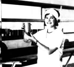 A Palmetto Canning employee holding a can beside the production line